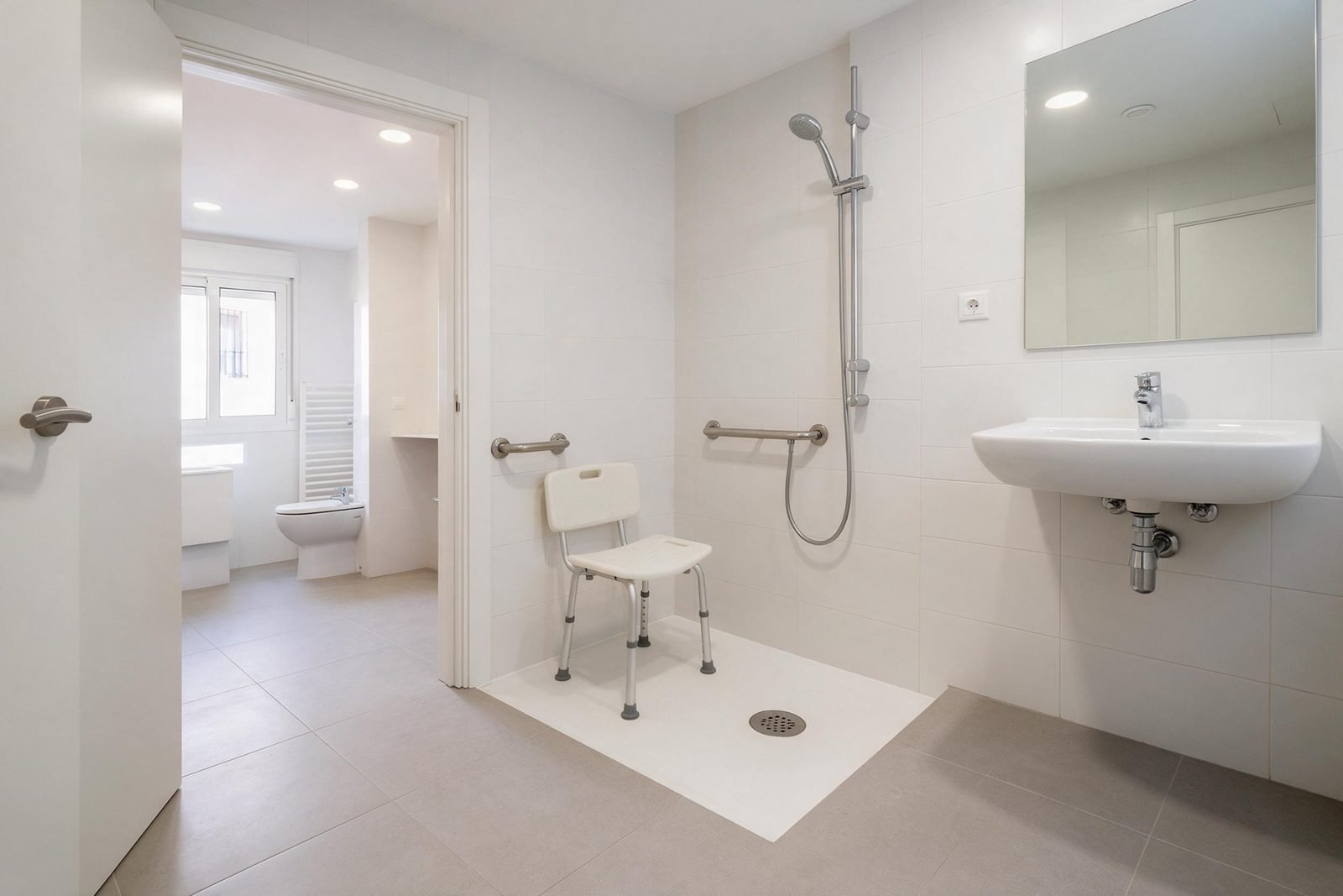 Baño adaptado para personas mayores en Madrid con ducha a ras de suelo, asiento abatible y asideros