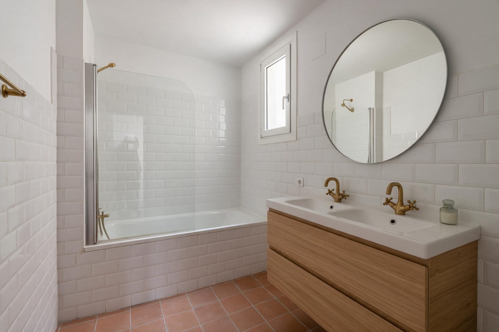 Baño reformado en Madrid con bañera, mampara fija y suelo de terracota