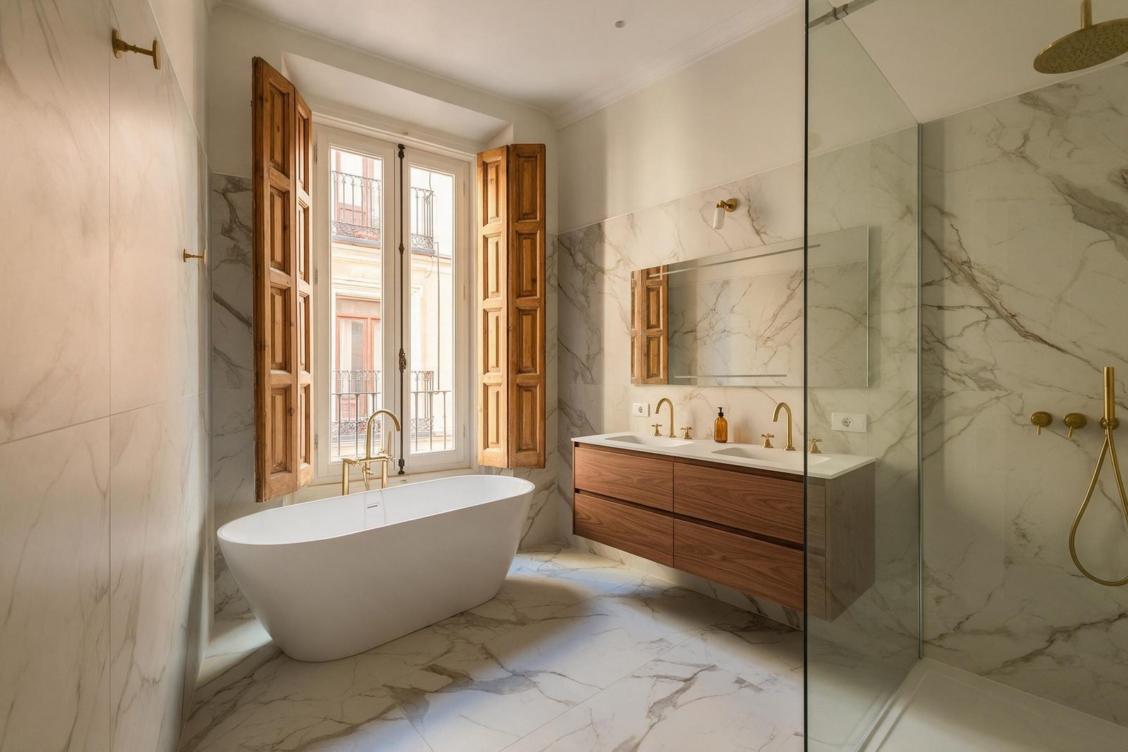 Baño principal reformado en Madrid con ducha corrida, doble hornacina y azulejo claro de gran formato