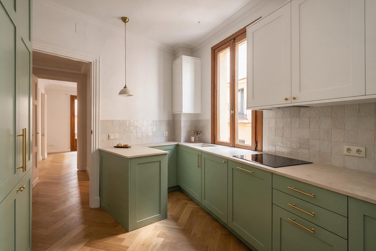 Despu&eacute;s: la misma cocina con muebles verde salvia, encimera de piedra y azulejo zellige