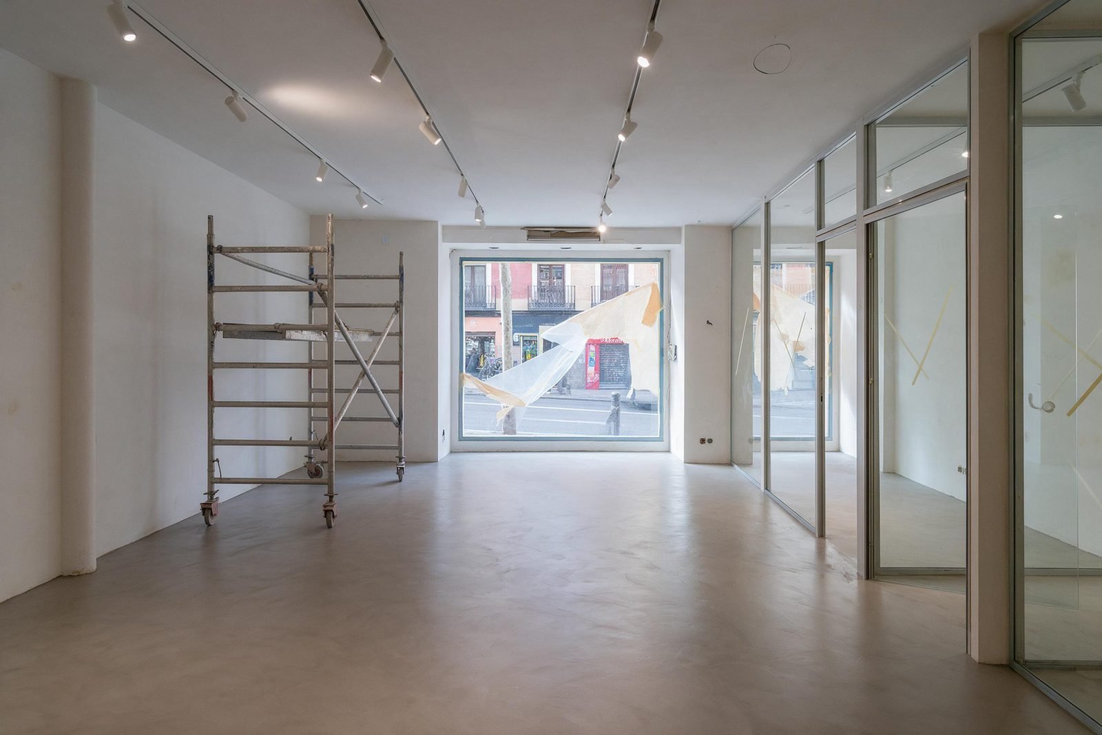 Local comercial en Madrid en fase de acabados, con microcemento y mamparas instaladas