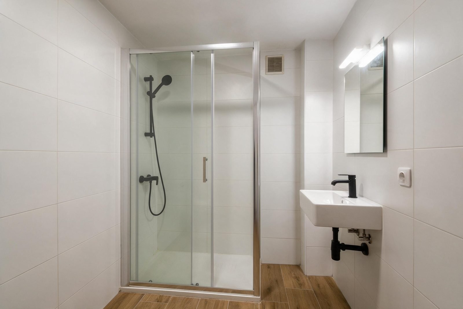 Segundo baño reformado en Madrid con ducha, lavabo sobre encimera y azulejo blanco biselado